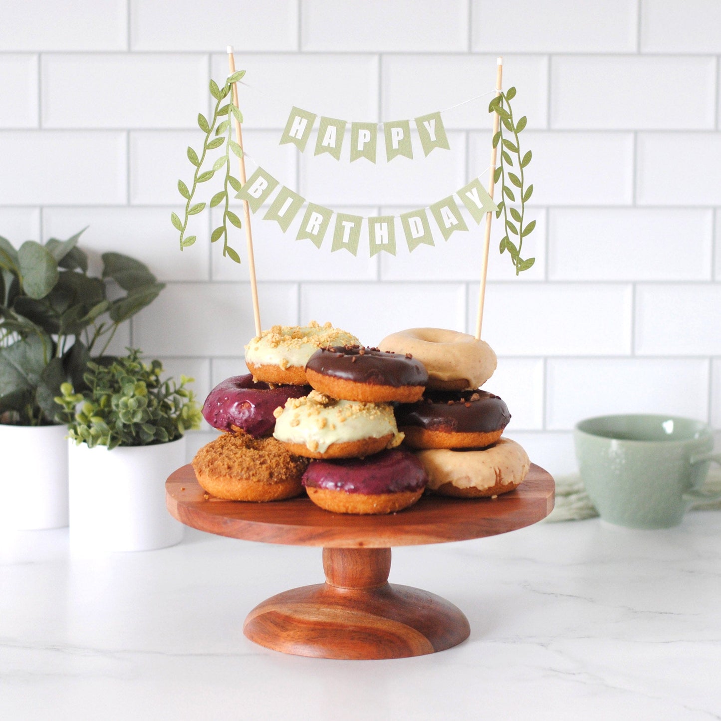 Happy Birthday cake topper in sage green with leaf tassels shown on plate of donuts | cake topper by Avalon Sunshine
