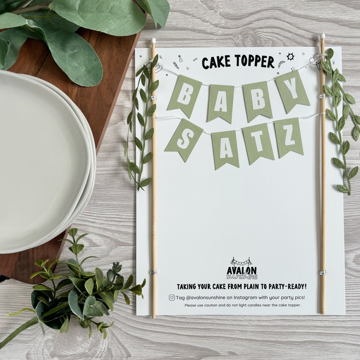 baby shower cake banner personalized with baby name for a greenery theme decor with leaf ribbon tassels on the ends | personalized cake toppers by Avalon Sunshine