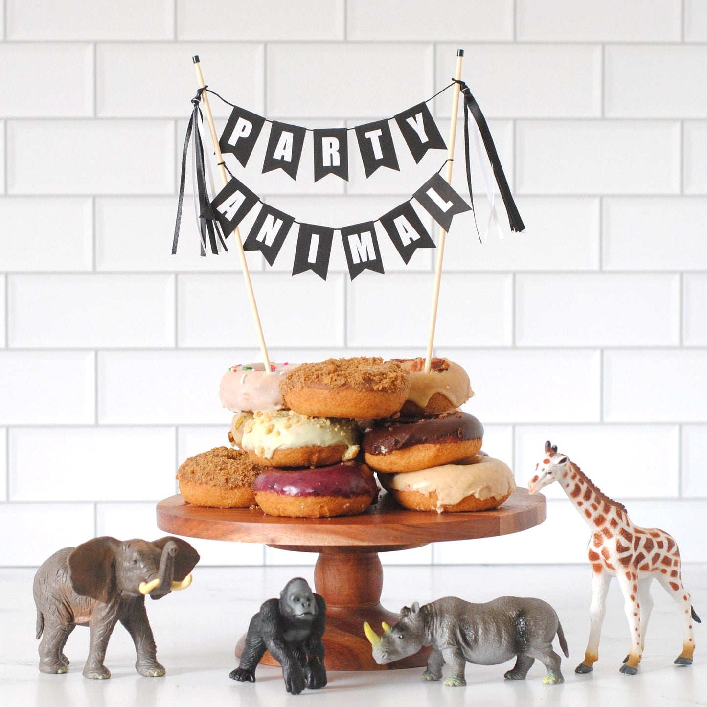 Party Animal theme cake topper on a stack of donuts decorated with toy animals | cake topper by Avalon Sunshine