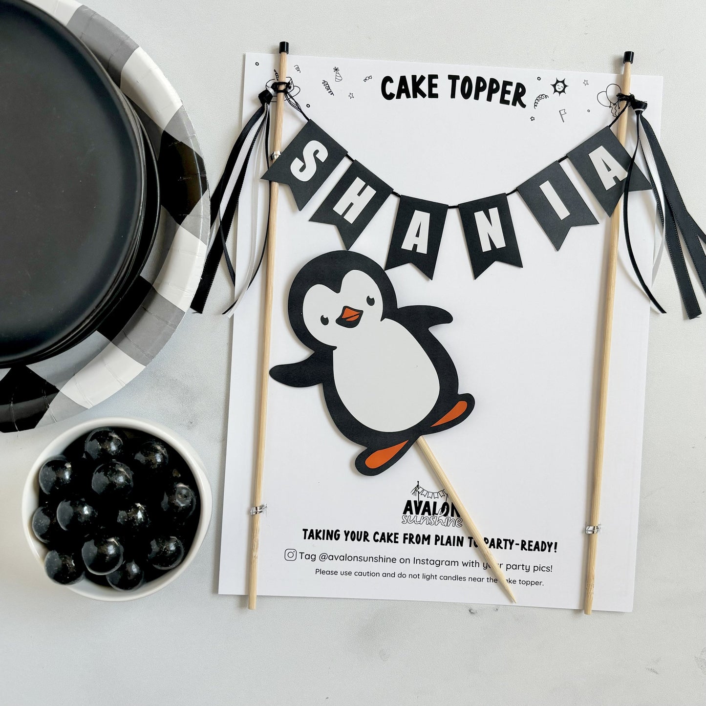 2 piece cake topper set for penguin theme birthday cake.  Personalized name banner in black and white and a penguin under the banner | personalized cake toppers by Avalon Sunshine