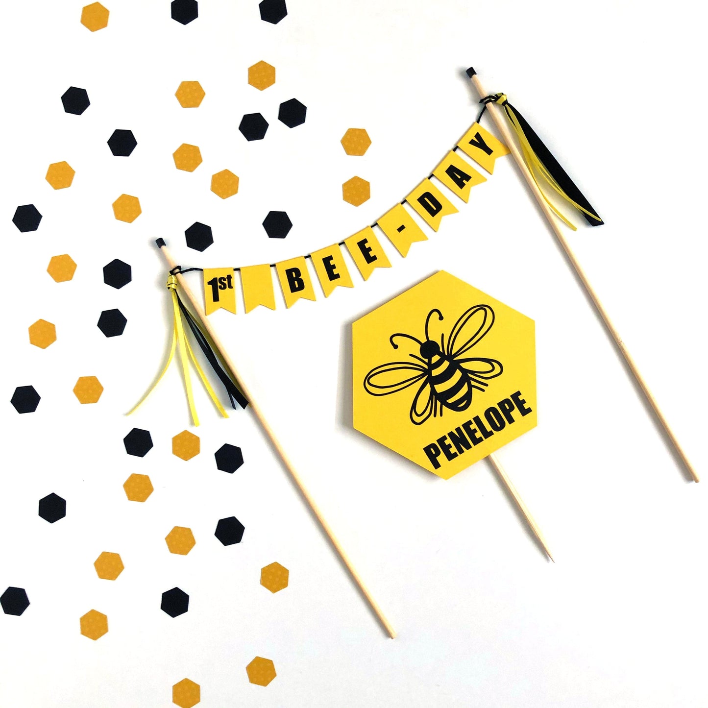 1st bee day cake banner with yellow hexagon shaped cake topper.  Topper has a black bee image personalized with name