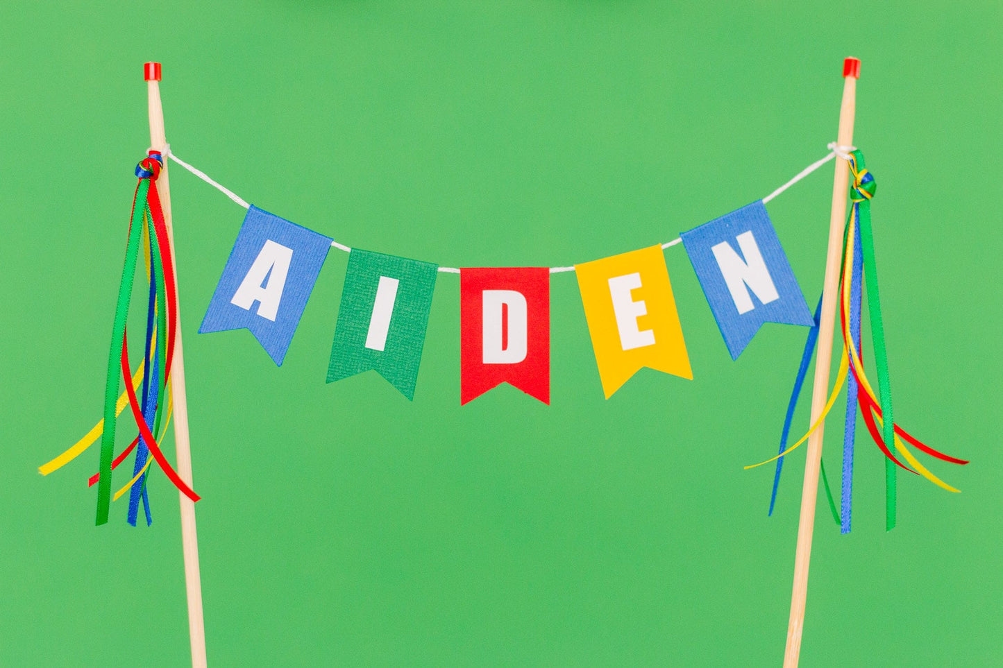 colorful  name cake topper in blue, green, red and yellow