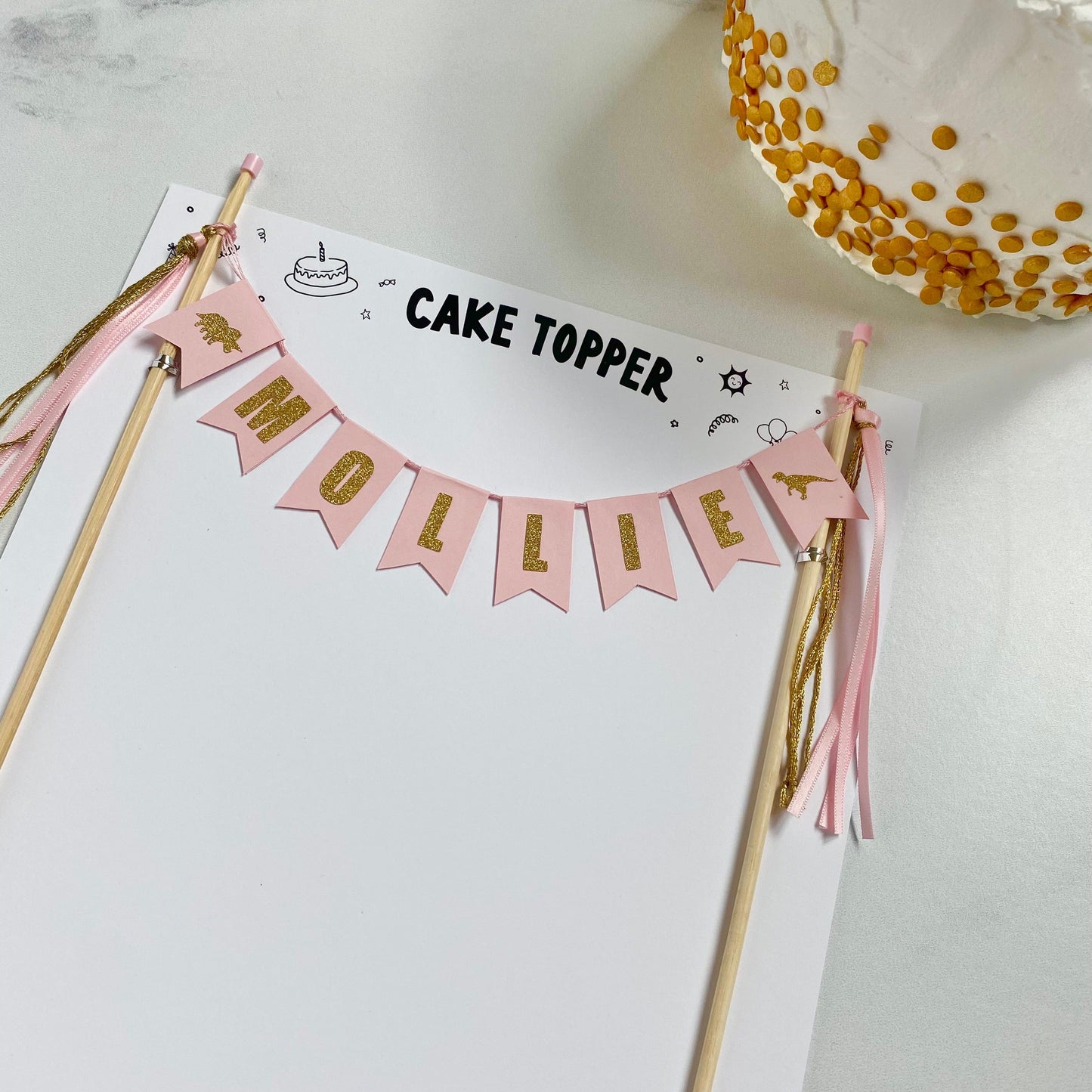 light pink and gold dinosaur theme cake topper personalized with name