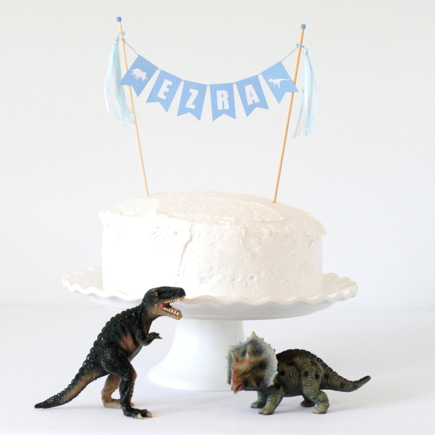 light blue cake topper with name personalized for dinosaur theme birthday party