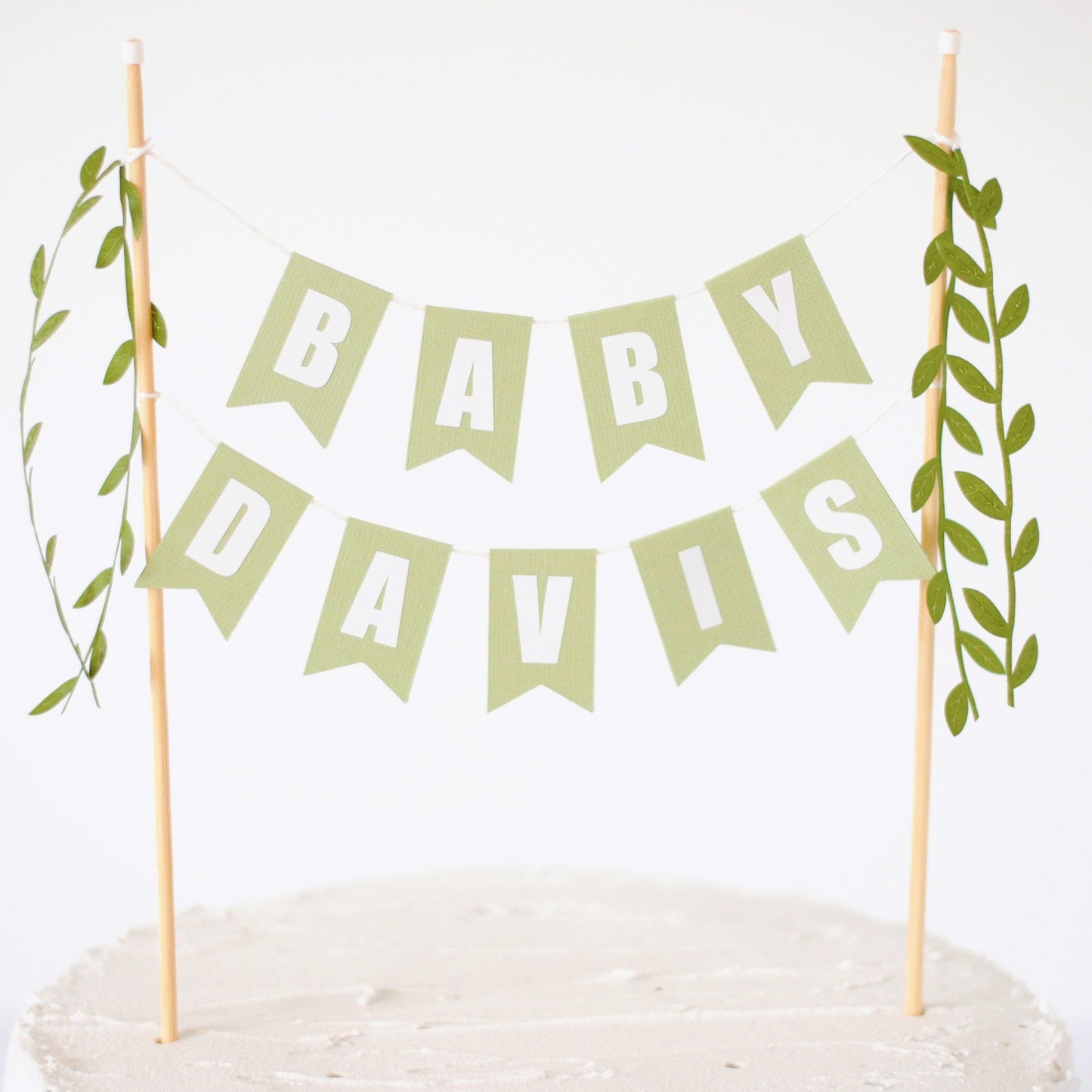 baby shower cake topper personalized with baby name and green leafy ribbons