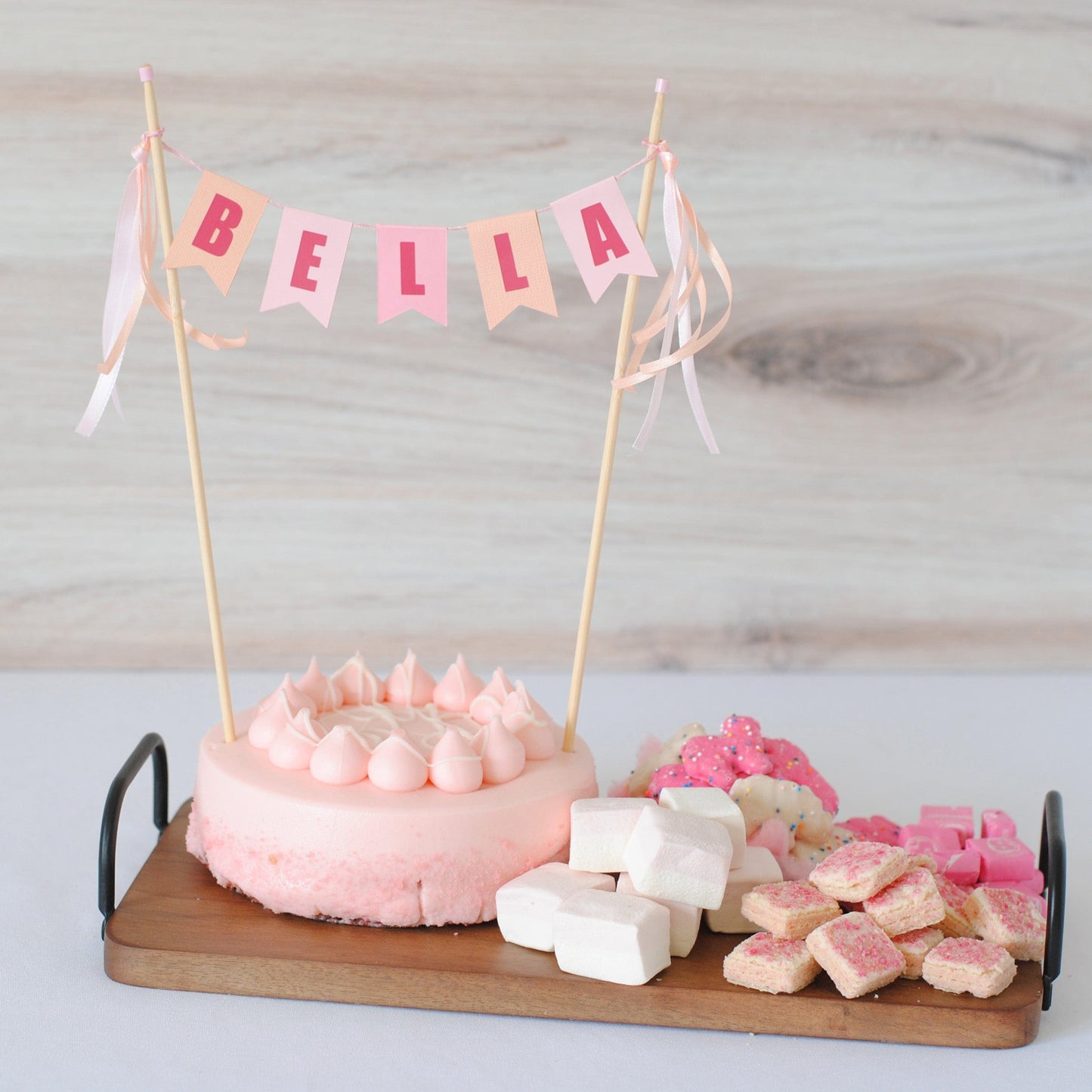 miniature cake on a small dessert charcuterie board with name cake topper on the cake