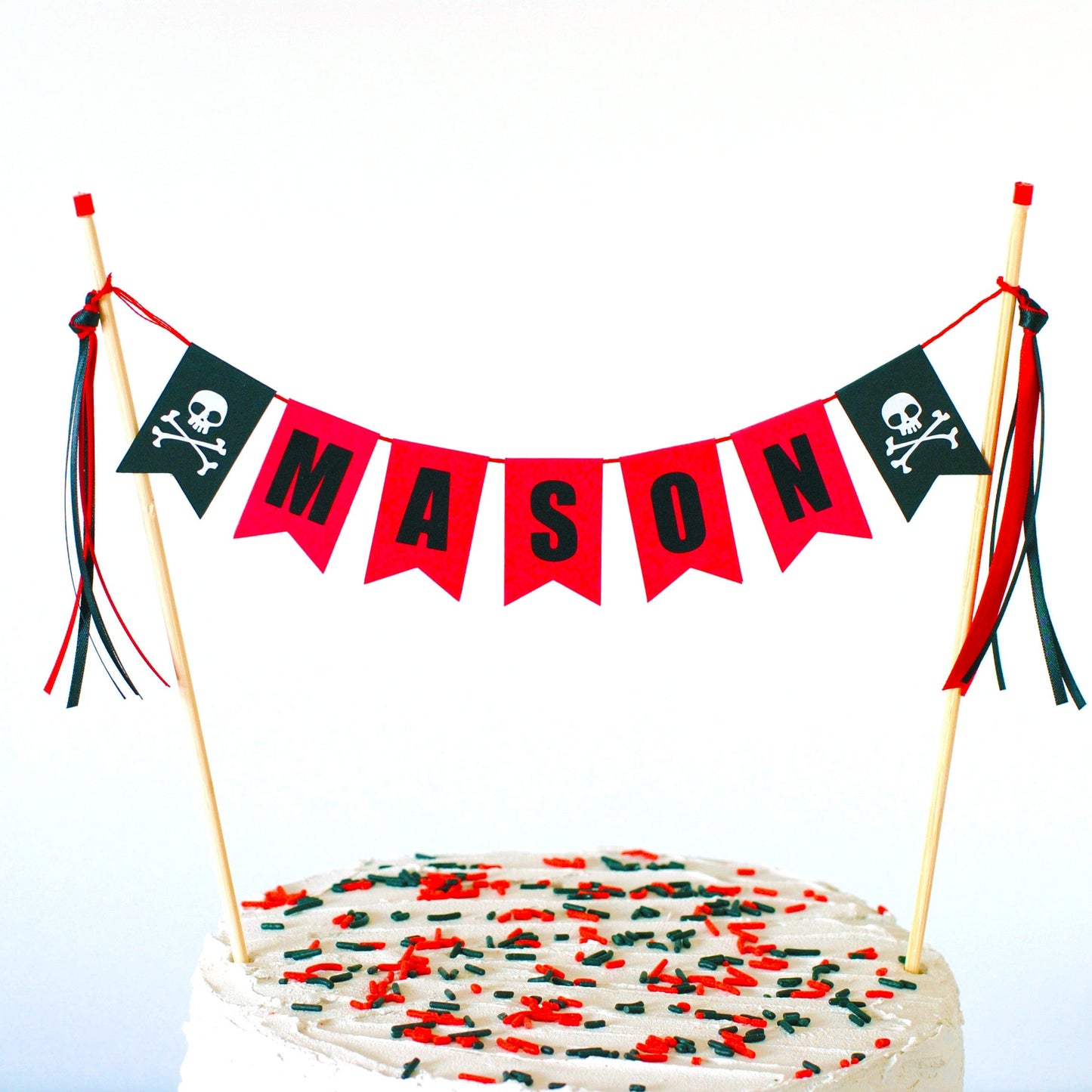 pirate theme birthday cake topper in red and black personalized with name and skull  and crossbones