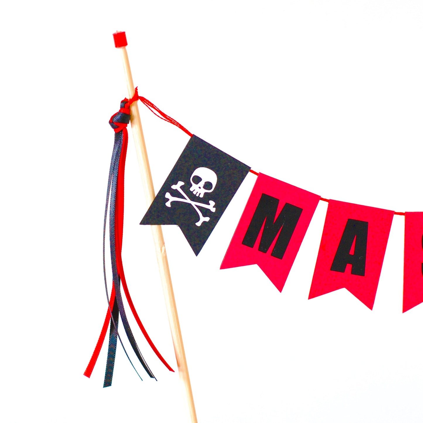 close-up of part of a pirate cake topper showing skull and crossbones on the end of a cake banner