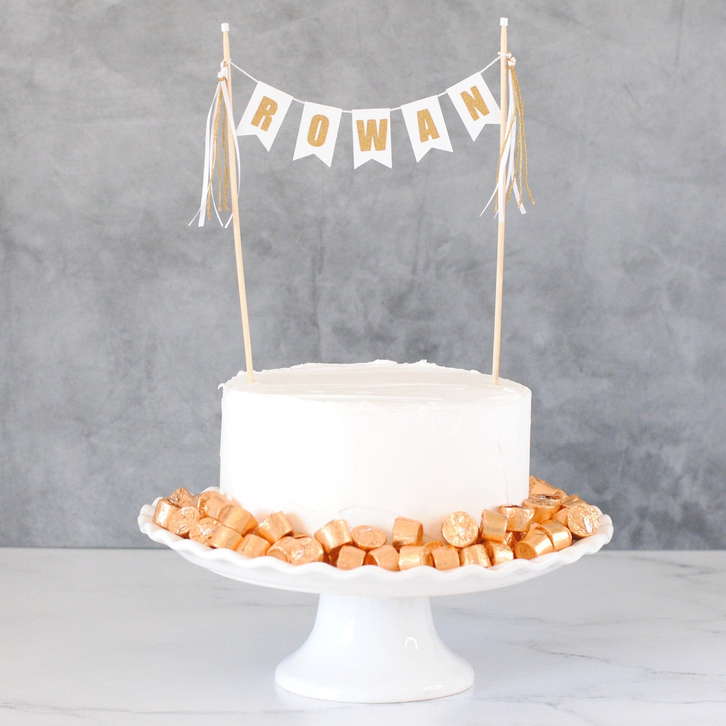 birthday cake topper in white and gold personalized with first name
