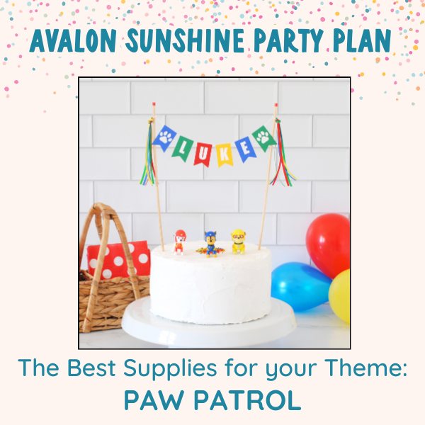 White birthday cake with colorful name banner with paw prints and paw patrol figures on top of the cake. The background has colorful balloons and party napkins