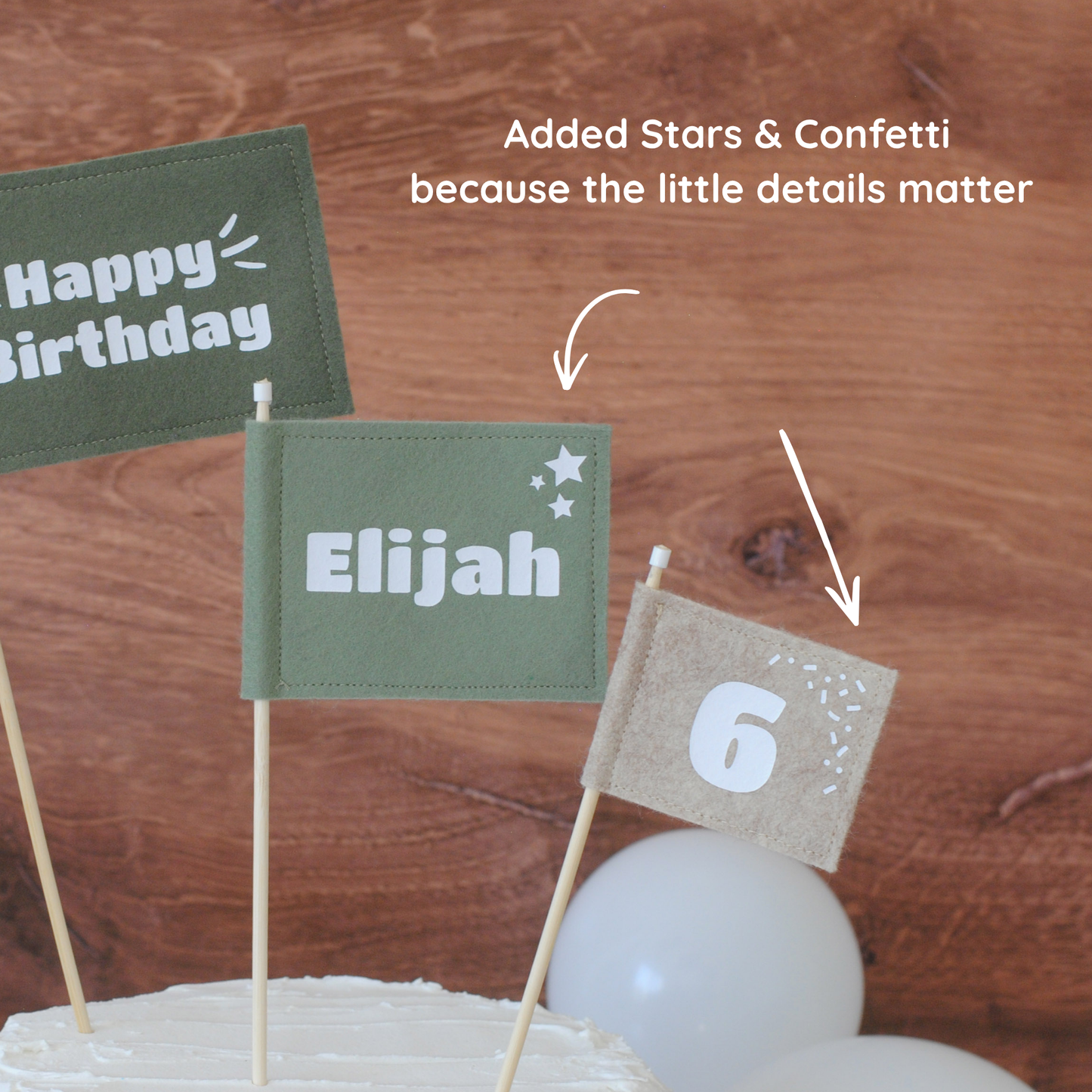 
                  
                    Close up details of felt flag cake toppers.  Medium size green flag has stars next to th personalized name and the small beige flag has age with confetti. 
                  
                