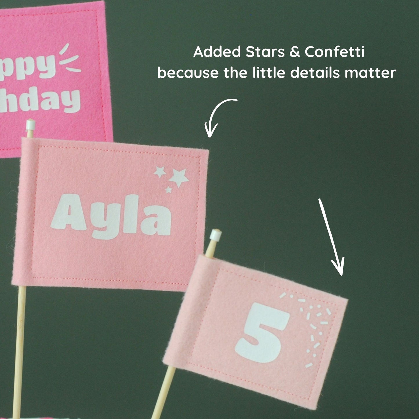
                  
                    Close-up details of pink felt flag cake toppers showing stars in the corner of the personalized name flag and confetti in the corner of the age/number flag.
                  
                
