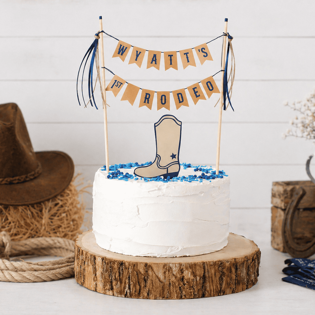 
                  
                    White cake with cowboy boot and 'WYATT'S 1ST RODEO' topper, surrounded by rustic decor.
                  
                