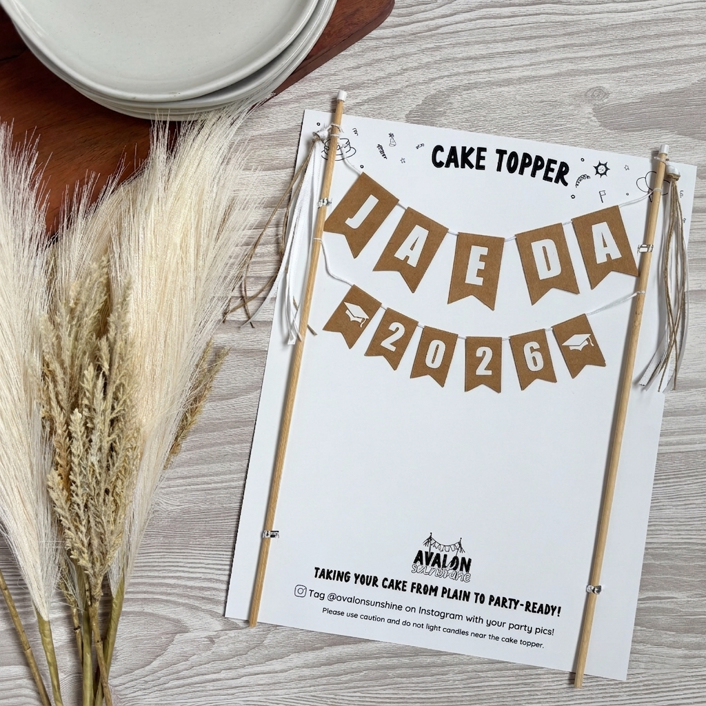 
                  
                    Neutral color graduation 2026 Cake topper with 'JAEDA 2026' text on a wooden surface with decorative elements.
                  
                