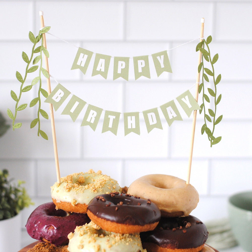 Happy Birthday cake topper in sage green with leaf tassels shown on plate of donuts | cake topper by Avalon Sunshine