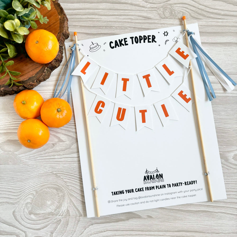 
                  
                    Cake Topper for LITTLE CUTIE themed baby shower - two tier cake banner with white paper flags and orange letters with wording "little cutie"
                  
                