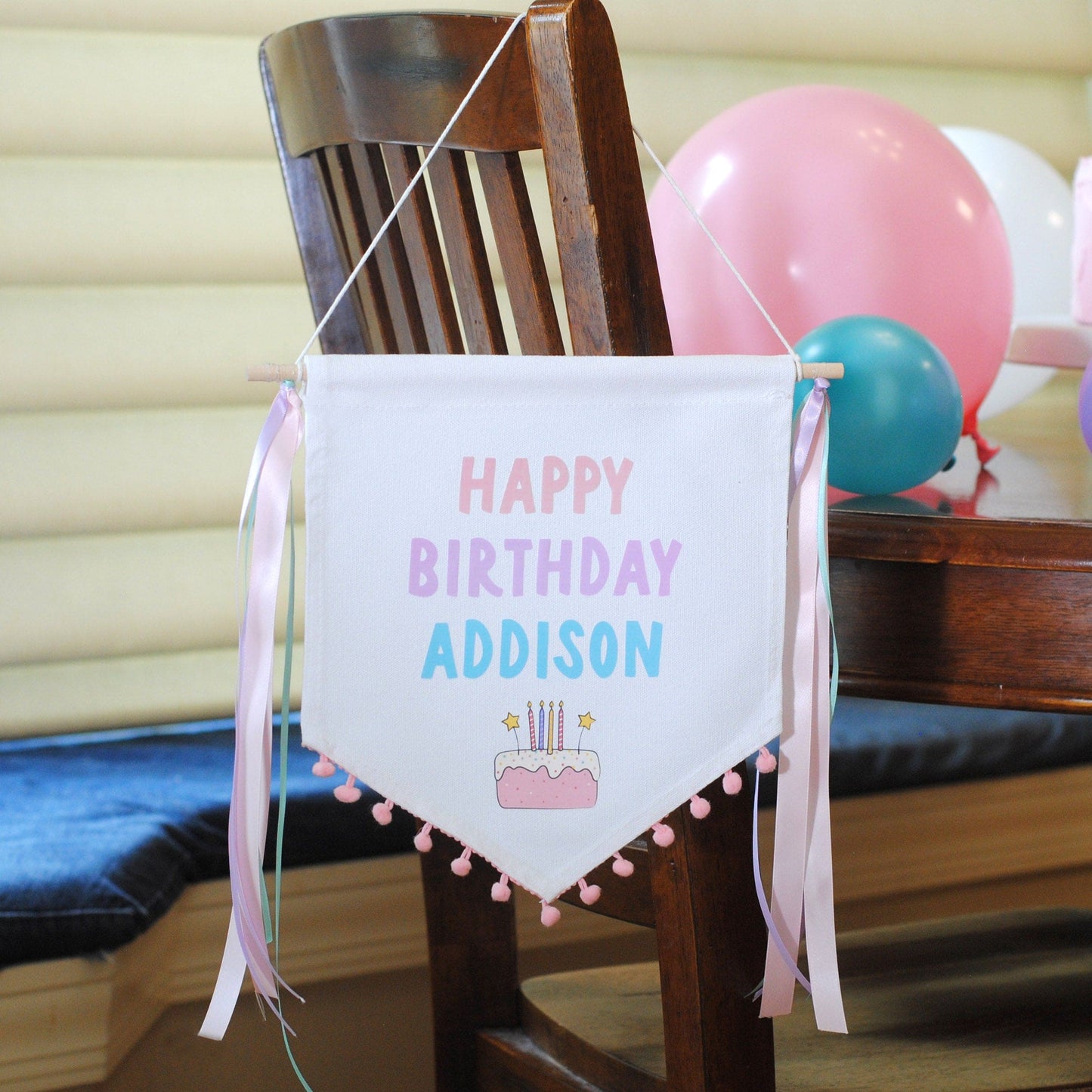canvas birthday banner in pastel colors with pom pom trim and ribbon tassels personalized with name 