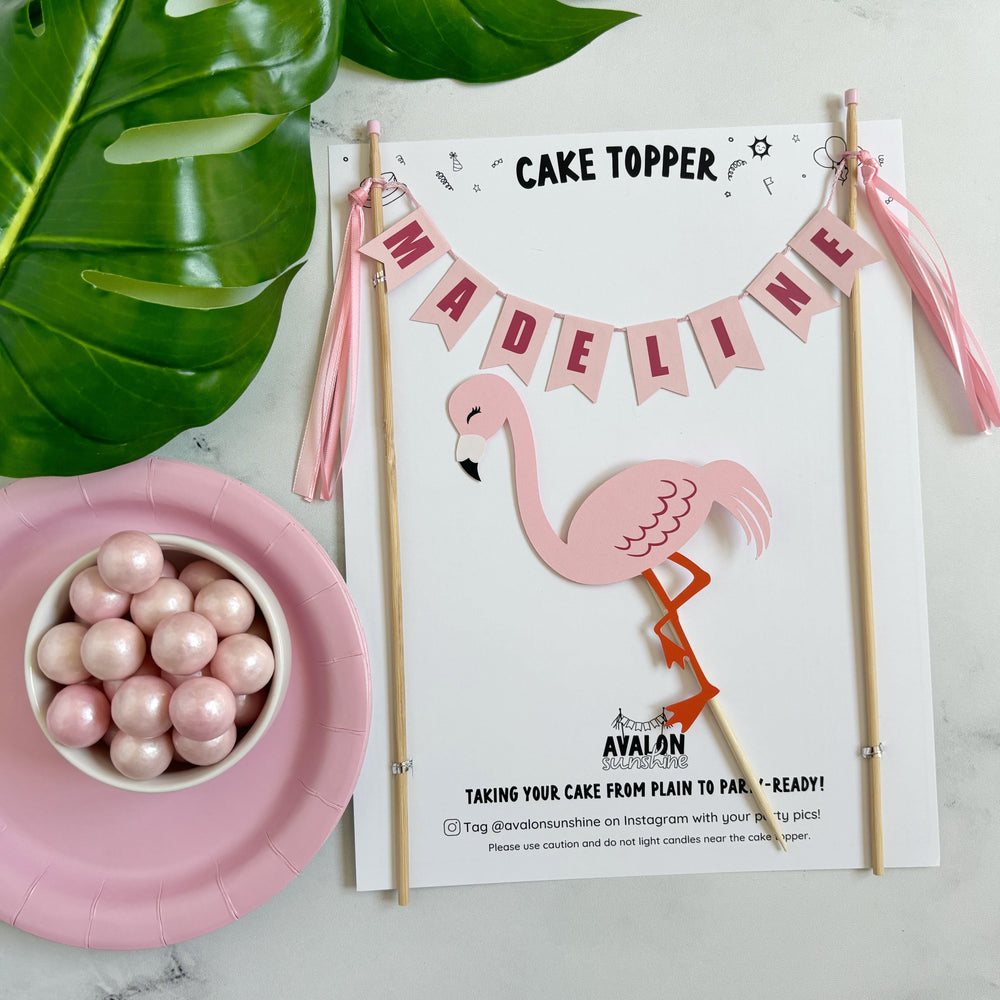 
                  
                    2 piece Flamingo theme birthday cake topper with name banner in shades of pink and a pink flamingo under the banner | personalized cake toppers by Avalon Sunshine
                  
                