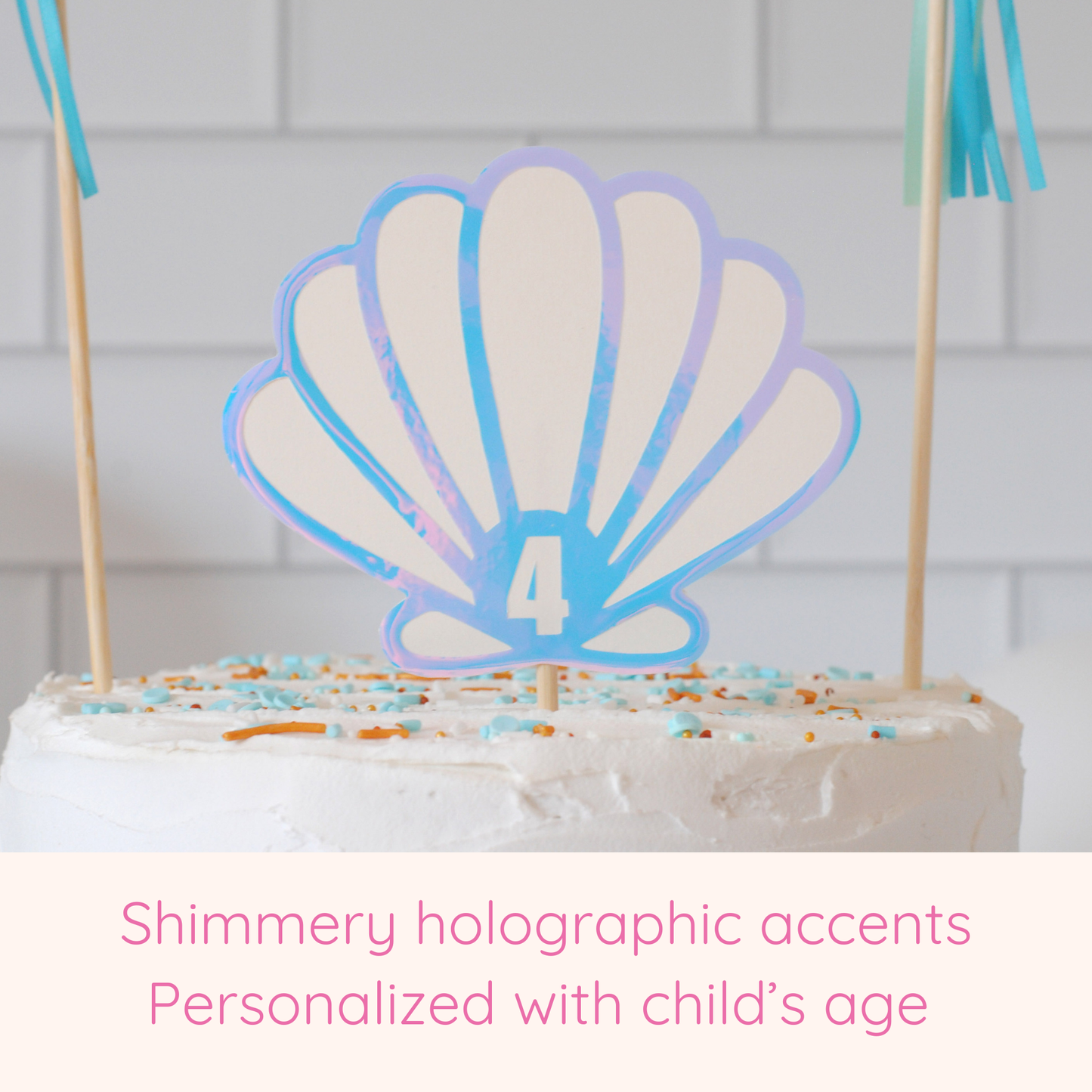 
                  
                    close up view of seashell cake topper showing the holographic accents and the child's age added to the seashell
                  
                