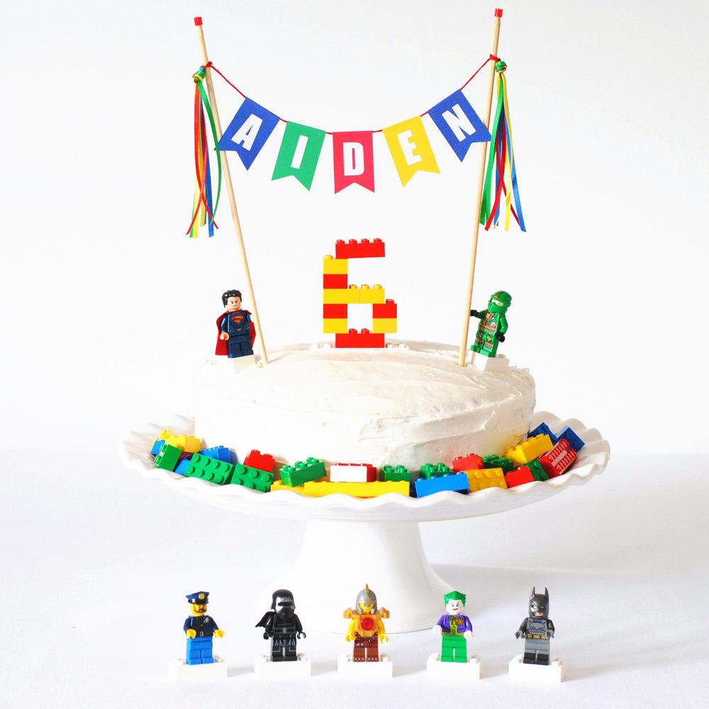 
                  
                    colorful name cake topper shown on a lego birthday cake
                  
                