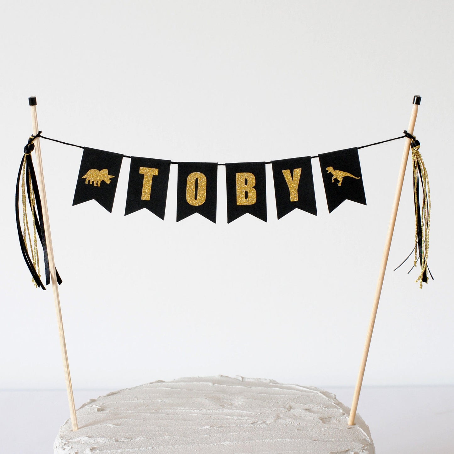 
                  
                    dinosaur theme cake topper name banner with black and gold letters
                  
                