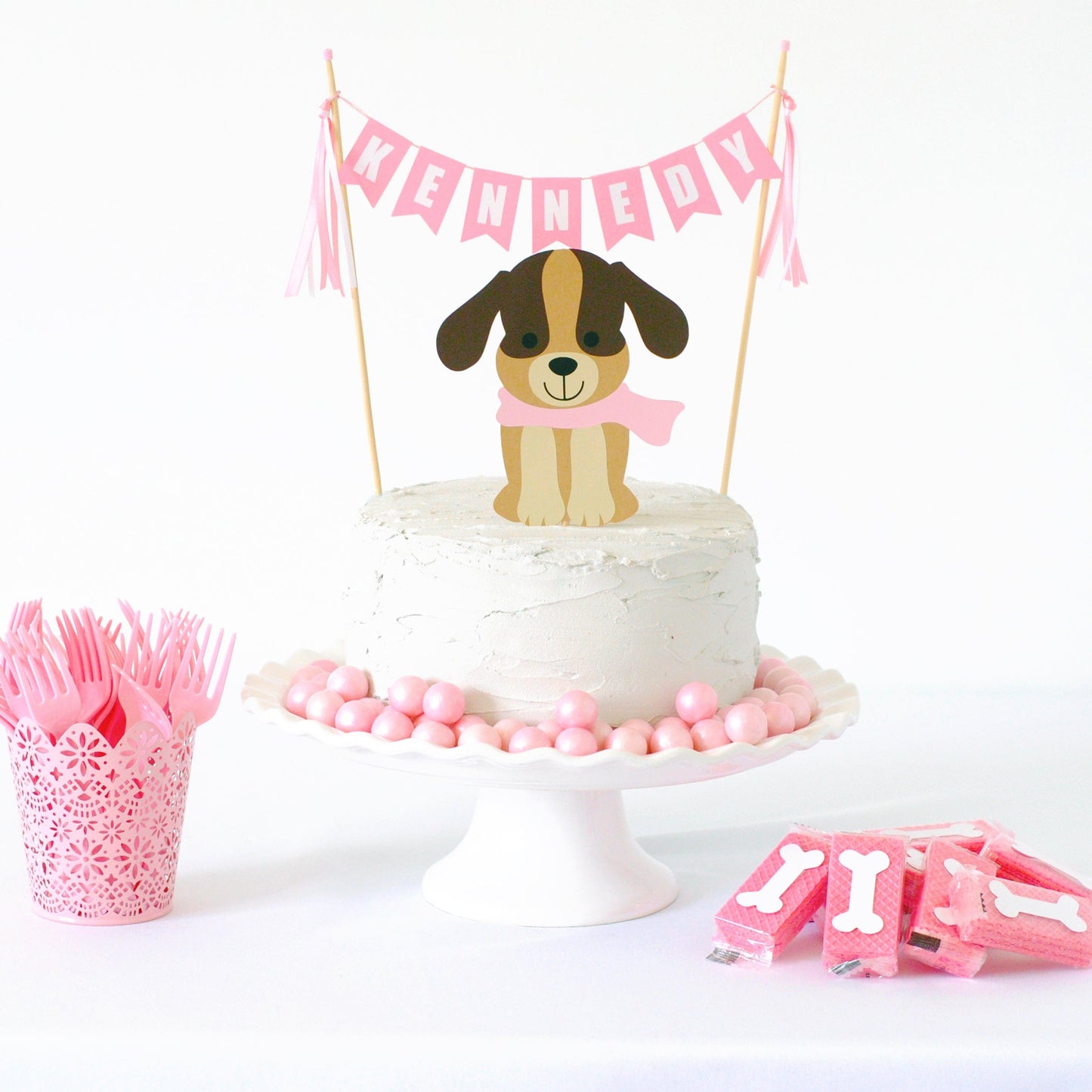 
                  
                    puppy birthday party cake topper set with brown dog wearing a light pink scarf and pink name cake banner
                  
                