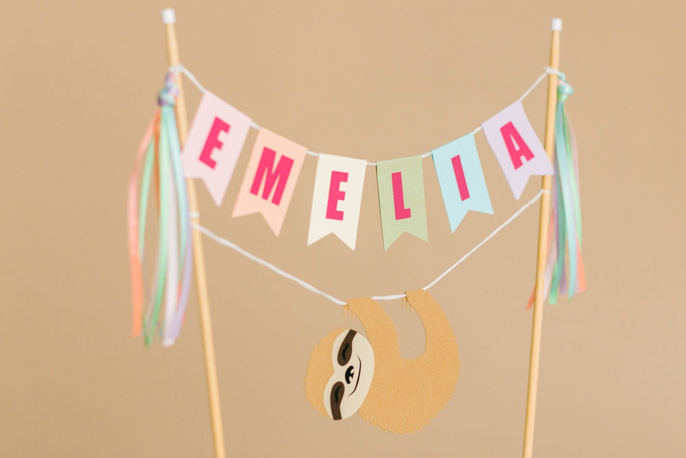 
                  
                    girls sloth birthday cake topper with name banner and hanging sloth
                  
                