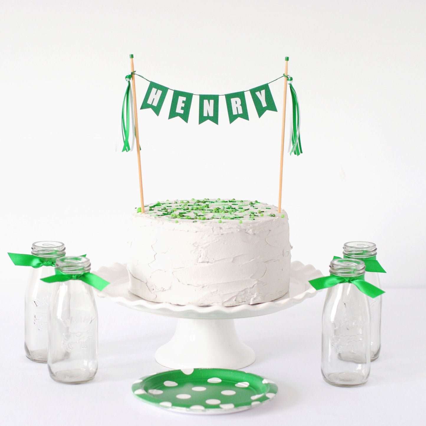
                  
                    birthday cake topper personalized with name shown in green and white colors
                  
                
