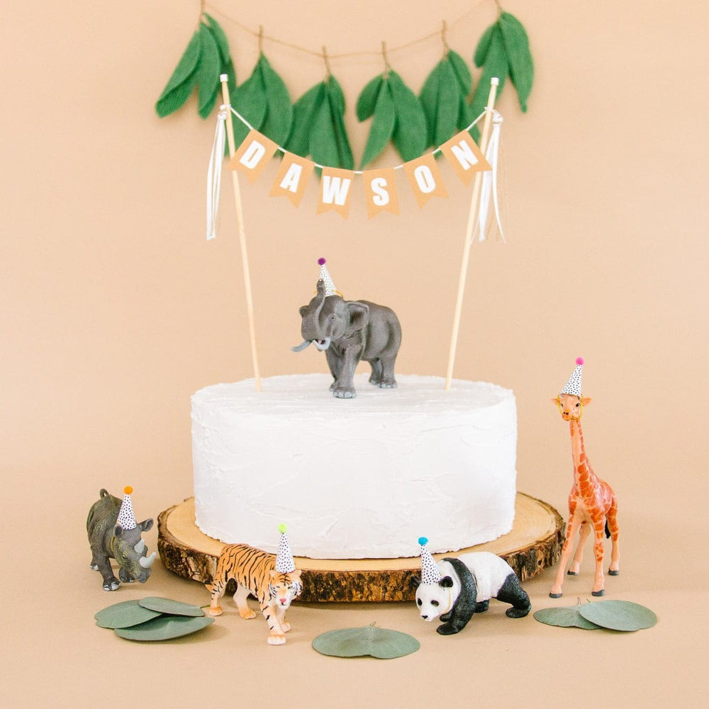 
                  
                    party animal themed birthday cake with safari toy animals and a personalized name cake topper
                  
                