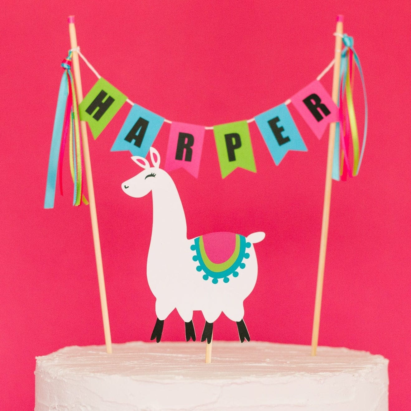
                  
                    llama birthday cake topper set with paper llama and personalized name banner in green, blue and pink
                  
                