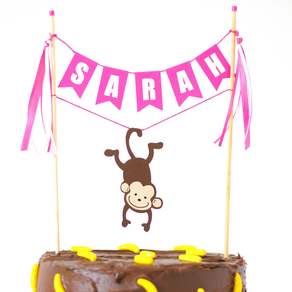 
                  
                    monkey cake topper for girls birthday cake  with personalized name banner and hanging monkey
                  
                