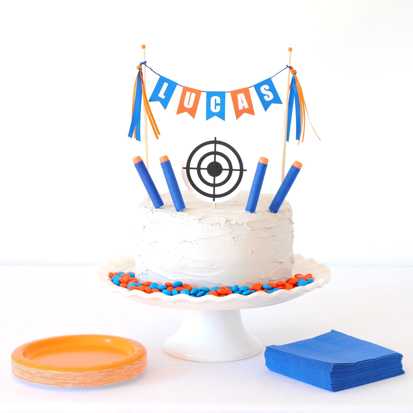 
                  
                    orange and blue personalized name cake topper with round target and nerf-style foam darts
                  
                