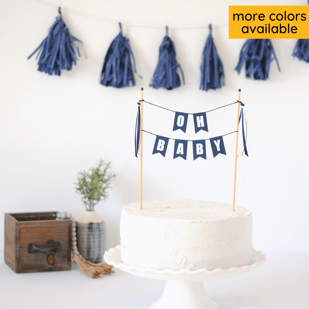 
                  
                    "oh baby" baby shower cake topper in navy blue with white letters shown on a white cake
                  
                