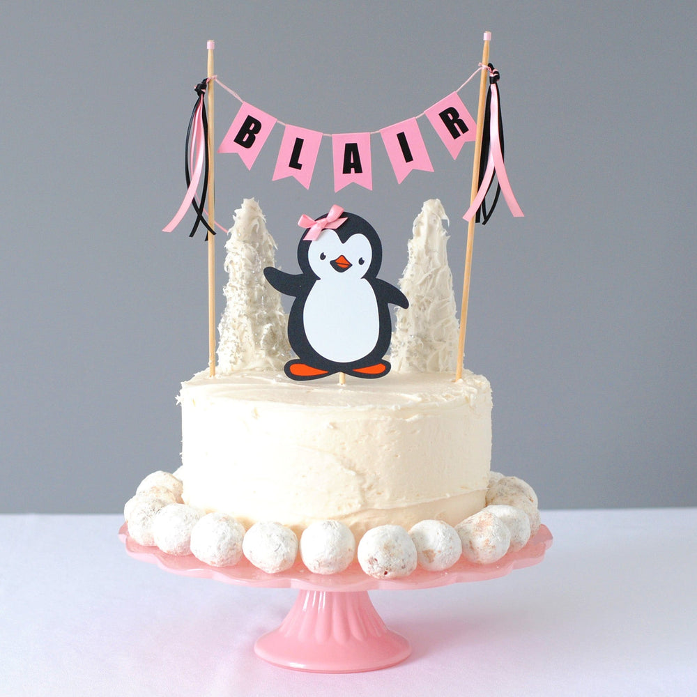 girl penguin birthday cake topper with paper penguin with a pink bow and a name cake banner