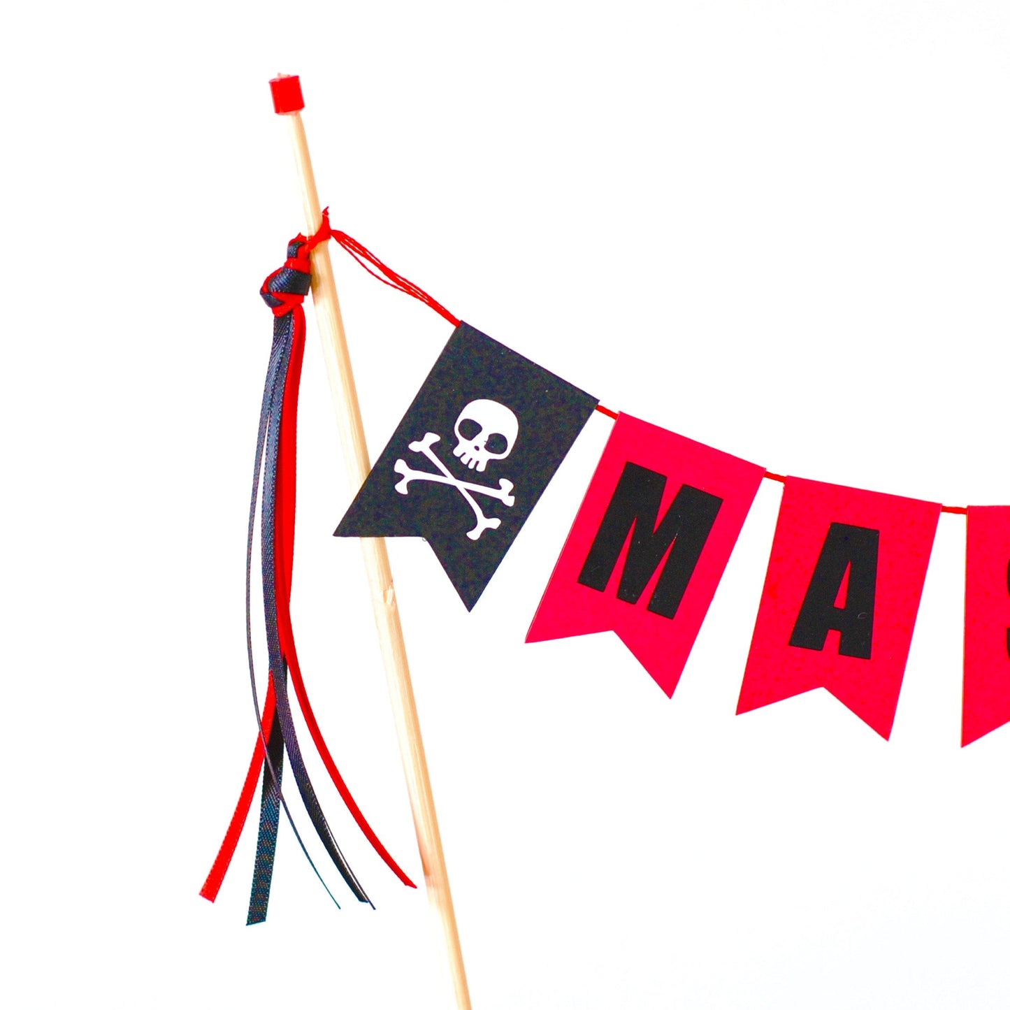 
                  
                    close-up of part of a pirate cake topper showing skull and crossbones on the end of a cake banner
                  
                