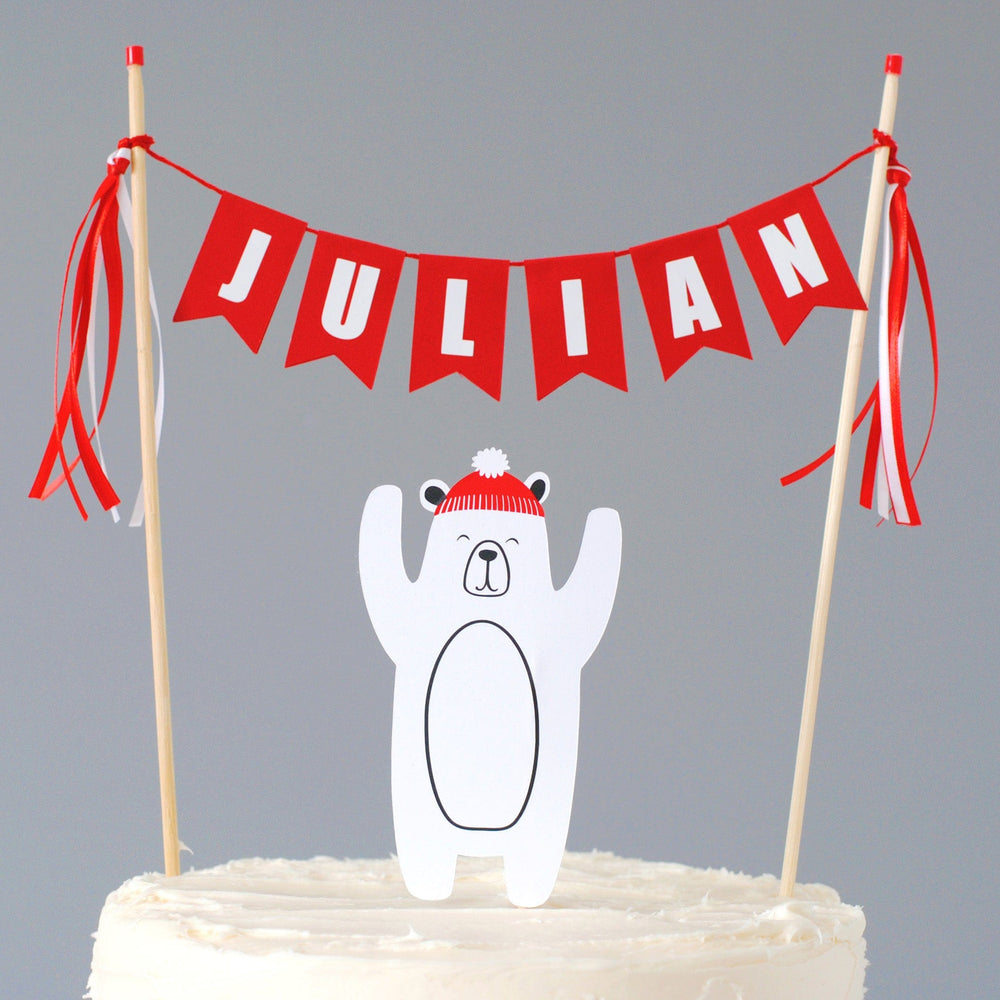 
                  
                    polar bear birthday cake topper set with polar bear wearing a red hat and red name cake banner
                  
                