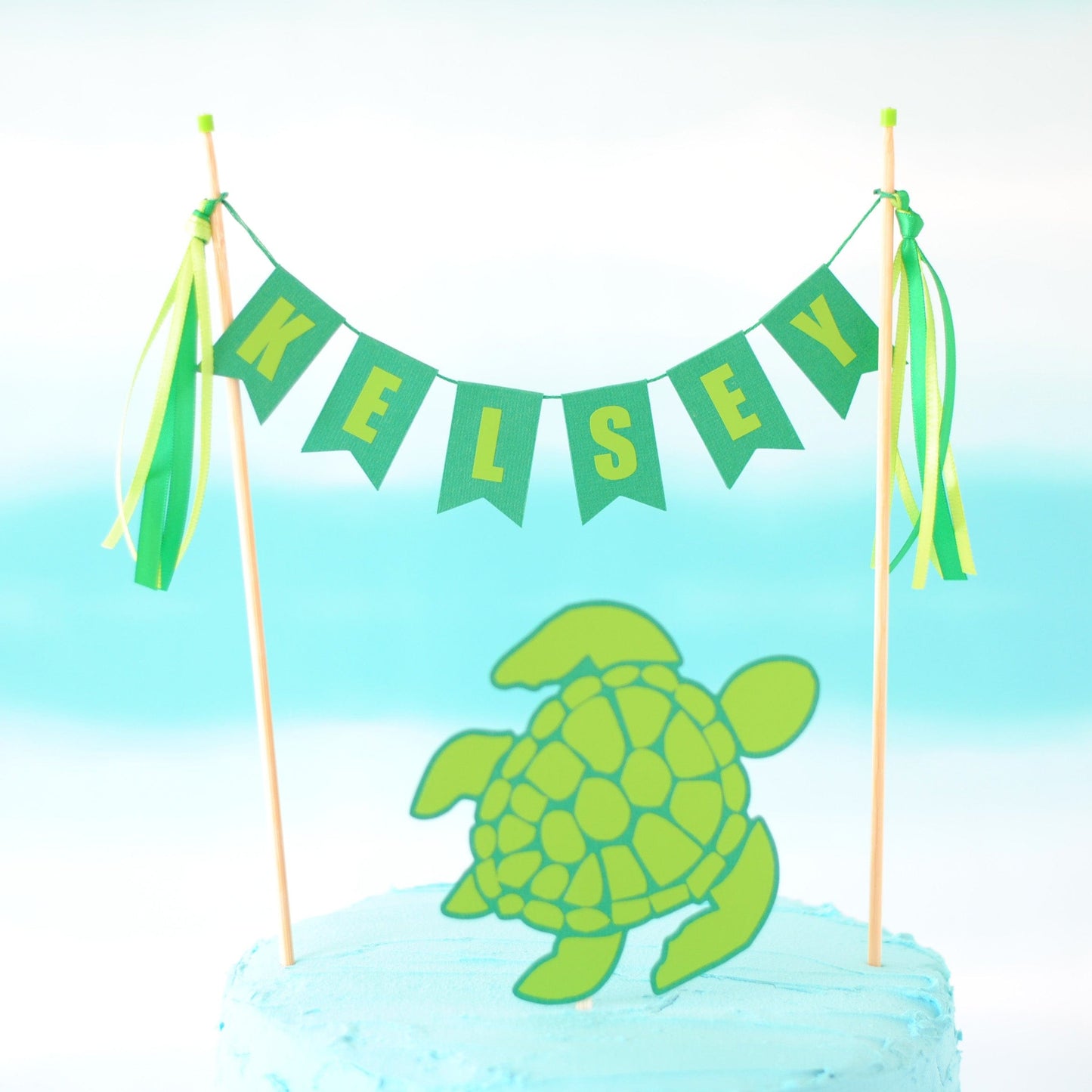 
                  
                    Sea Turtle cake topper set with personalized name banner and a separate turtle topper
                  
                